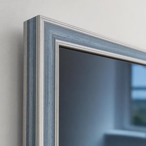 Può includere: Una cornice rettangolare caratterizzata da un design multistrato con strisce verticali alternate in blu tenue e bianco sporco. La cornice presenta una finitura testurizzata con un profilo a gradini, creando profondità e un bordo pulito e strutturato.