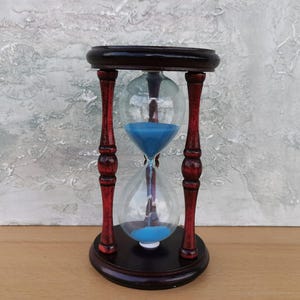 Può includere: Una tazza di ceramica bianca con manico nero e la scritta "But First, Coffee" in grassetto nero. La tazza è appoggiata su una superficie bianca. La tazza è alta circa 10 cm.