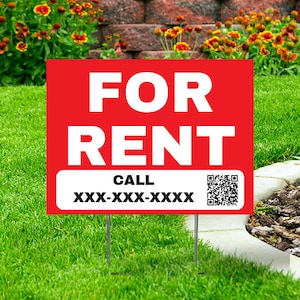 May include: A red "FOR RENT" sign with white text and a white section at the bottom that says "CALL" and a phone number. The sign is in a grassy yard with flowers and a brick wall in the background.