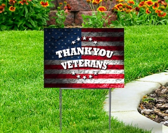May include: A red, white, and blue American flag with a distressed, textured look. The flag has the words "Thank You Veterans" in white text.