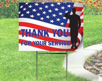 May include: A yard sign with the American flag design and the words "THANK YOU FOR YOUR SERVICE" in red and blue. A silhouette of a saluting soldier is on the right side of the sign. The sign is displayed on a green lawn.