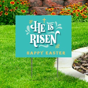 May include: A teal blue yard sign with the text "He is Risen" in white with a gold cross above the text. The text "Happy Easter" is in gold below the main text.