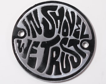 May include: A round, silver metal disc with black lettering that reads "In Shovel We Trust".