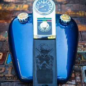 Peut inclure: Un r&eacute;servoir de moto bleu avec un compteur de vitesse et des d&eacute;tails chrom&eacute;s. Une sangle en cuir noir avec un motif de Marilyn Monroe et des pistolets crois&eacute;s est attach&eacute;e. Le r&eacute;servoir a deux bouchons de carburant chrom&eacute;s.