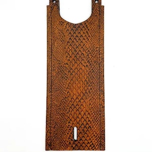 Puede incluir: Consola de depósito de gasolina de motocicleta de cuero marrón con un patrón de piel de serpiente.