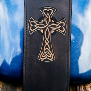 Peut inclure: Une console de réservoir de moto en cuir noir avec un motif de croix celtique marron.