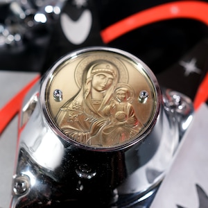 Könnte beinhalten: Ein silberner und goldener Motorrad-Anhänger mit einem religiösen Bild der Jungfrau Maria, die ein Jesuskind hält. Der Anhänger ist rund und hat einen erhöhten Rand.