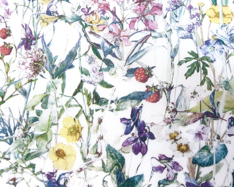May include: A white fabric with a floral pattern featuring various flowers, leaves, and berries in shades of pink, purple, yellow, and green.