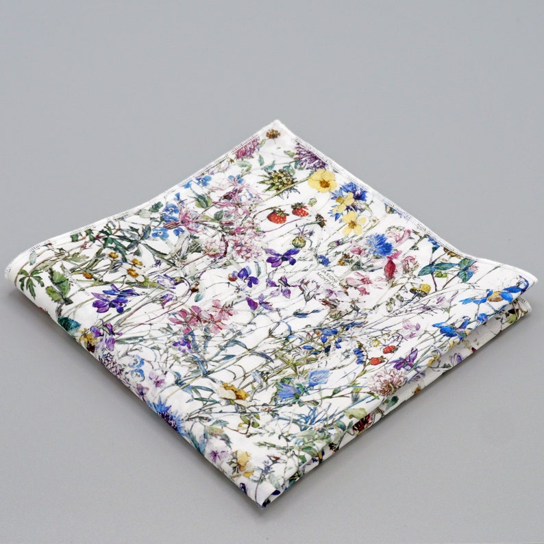 May include: A white cotton handkerchief with a floral print featuring a variety of colorful flowers and leaves.