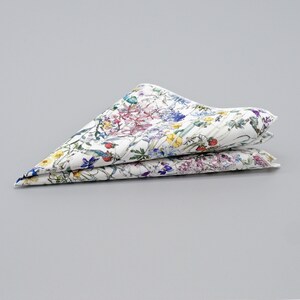 May include: A white cotton pocket square with a floral print featuring a variety of colorful flowers and leaves.