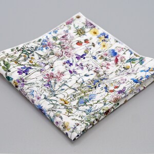 May include: A white cotton pocket square with a floral pattern featuring a variety of colorful flowers and leaves.