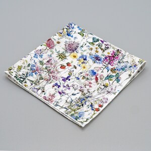 May include: A white cotton handkerchief with a floral print featuring a variety of colorful flowers and leaves.