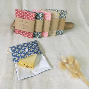 May include: Five fabric soap pouches with different geometric patterns in red, pink, beige, blue, and white. The pouches are lined with white fabric and have a button closure. One pouch is open and contains a bar of soap.