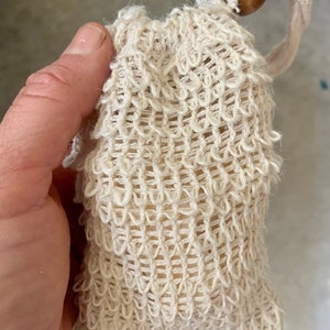 May include: A white crocheted soap bag with a wooden bead on the drawstring.