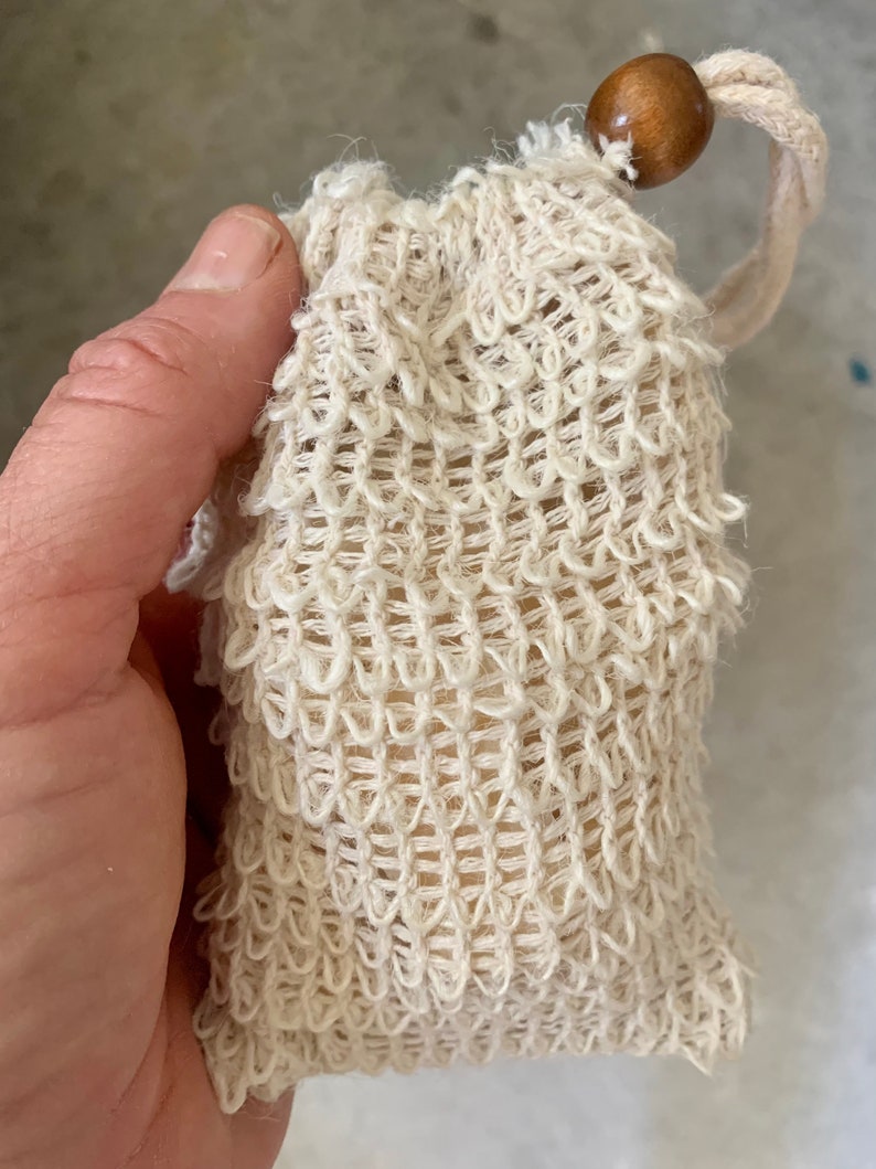 May include: A white crocheted soap bag with a wooden bead on the drawstring.