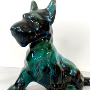 May include: A white ceramic mug with a black handle and the text "But First, Coffee" in a handwritten style. The mug is on a white surface. The mug is approximately 4 inches tall.