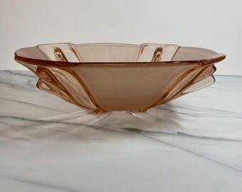 Könnte beinhalten: Eine Vintage-Glasschale in hellem Rosa mit einem einzigartigen, gewellten Design. Die Schale hat eine quadratische Form mit gebogenen Kanten und einem leicht erhöhten Boden. Das Glas hat eine subtile, durchscheinende Qualität. Die Schale scheint in ausgezeichnetem Zustand zu sein.