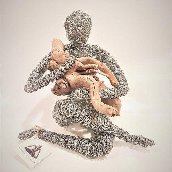 Pietà ,a unique handmade iron wire sculpture. a human figure holding a salted piece of wood from dead sea.