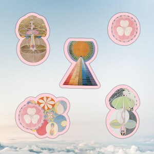 Puede incluir: Conjunto de cinco pegatinas troqueladas con ilustraciones abstractas coloridas con un borde rosa claro. Los diseños incluyen una pirámide con un sol, una flor y otras formas geométricas. Las pegatinas están sobre un fondo de cielo.
