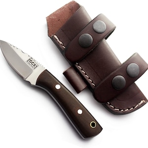 May include: A small, brown-handled knife with a stainless steel blade and a serrated edge. The knife has a white dot on the handle and the text "G.C.S. Custom Knives" is engraved on the blade. The knife is in a brown leather sheath with two straps and snaps.