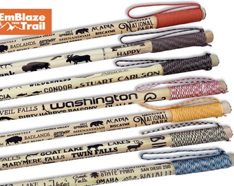 May include: A set of six wooden walking sticks with different colored cords and engraved text. The text includes names of national parks, cities, and landmarks. The sticks are approximately 36 inches long.