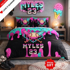 May include: A baseball-themed bedding set with a black comforter featuring a baseball and bat design, pink drips, and the name "MYLES 23". Includes matching pillowcases and a wall sign with the same design.