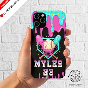 May include: A black phone case featuring a baseball design with pink and blue dripping icing. The design includes a baseball, crossed bats, and the name "MYLES" with the number "23". The case has a turquoise top with sprinkles.