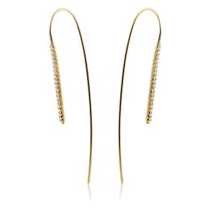 May include: A pair of gold dangle earrings with a line of small clear stones on each earring.