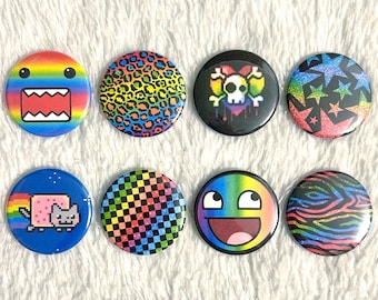 May include: A collection of eight colorful round buttons with various designs. The designs include a rainbow-colored face, leopard print, a skull with a rainbow heart, stars, a Nyan Cat, a checkered pattern, a meme face, and a zebra pattern.