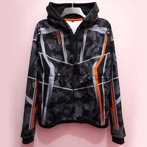 May include: A black zip-up hoodie with a geometric camouflage pattern in shades of grey and white, accented with orange stripes. The hoodie has a drawstring at the waist and a hood. The garment is hanging on a white hanger.
