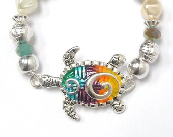 Pulsera elástica con diseño de tortuga marina en tono plateado texturizado y esmalte de colores del arcoíris con cuentas de turquesa y perlas BRLT-TURTLE-01