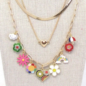 May include: A gold layered necklace with colorful enamel charms, including a heart, a cloud, a flower, a rainbow, and an umbrella.