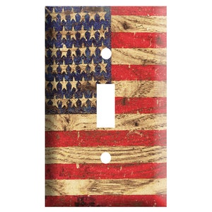 May include: A light switch cover featuring a distressed American flag design with red, white, and blue colors on a woodgrain background.