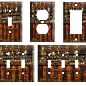 May include: Set of four light switch and outlet covers featuring a vintage bar scene with wooden walls, shelves stocked with bottles, and bar stools. The scene is lit by hanging lights and has a warm, inviting atmosphere.