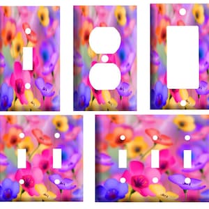 May include: Set of six light switch and outlet covers featuring a colorful floral pattern with pink, yellow, orange, and purple flowers. The covers are designed to fit standard US electrical outlets and switches.