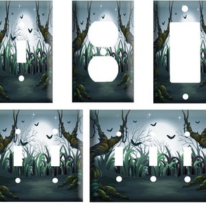 May include: Three different light switch and outlet covers featuring a spooky Halloween scene with a full moon, trees, and bats. The scene is set in a dark forest with a path leading to the moon.
