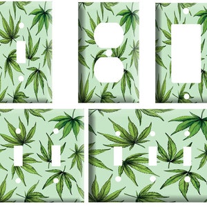 May include: A set of light green wall plates featuring a repeating pattern of green cannabis leaves. The set includes plates for a single switch, a double outlet, a single outlet, a double switch, and a triple switch.