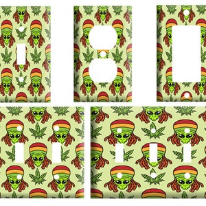 May include: Set of light switch and outlet covers featuring a green alien with dreadlocks wearing a red, yellow, and green hat, and green marijuana leaves on a light green background.