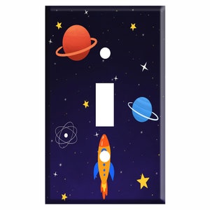 May include: A light switch cover with a space theme. It features a rocket, planets, stars, and an atom on a dark blue background.