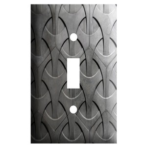 May include: A gray and white light switch cover with a geometric pattern.