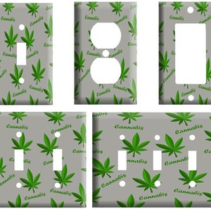 May include: Set of four light switch and outlet covers featuring a repeating pattern of green marijuana leaves and the word "Cannabis" on a gray background.