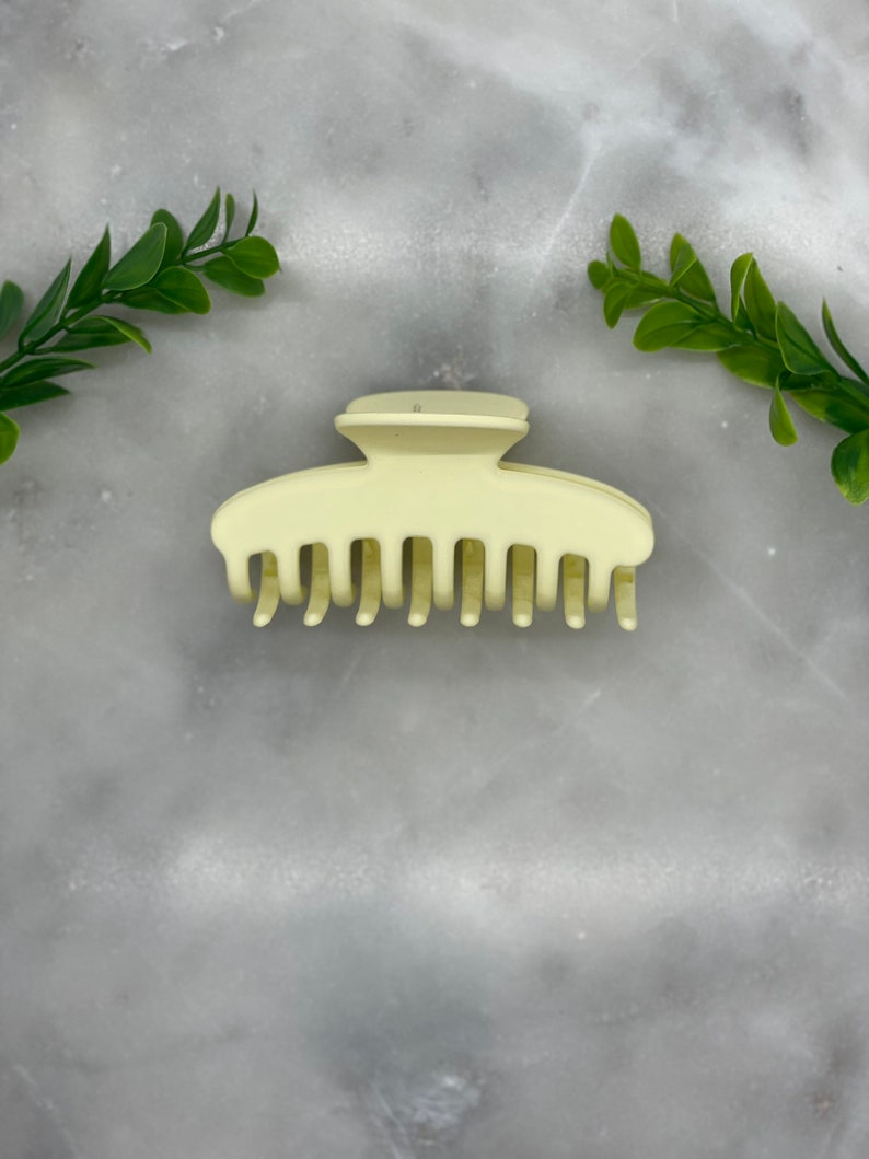 Peut inclure: Une pince &agrave; cheveux en plastique jaune clair avec une finition lisse.