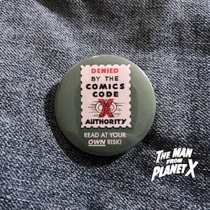 May include: A green button with a white stamp that reads "DENIED BY THE COMICS CODE AUTHORITY" and "READ AT YOUR OWN RISKI". The stamp has a red "A" with a circle around it.