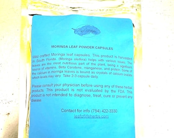 May include: A package of Moringa Leaf Powder Capsules. The package has a blue label with the text "MORINGA LEAF POWDER CAPSULES" and a drawing of a leaf. The text on the label describes the product's origin and use.