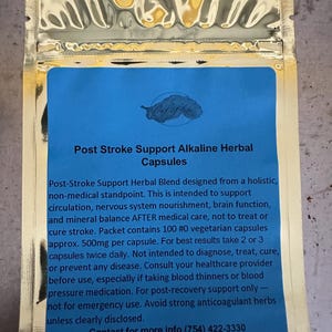 May include: A gold foil packet with a blue label. The label reads "Post Stroke Support Alkaline Herbal Capsules." Text on the label describes the product's purpose and usage. The packet contains 100 vegetarian capsules.