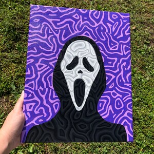 May include: A purple and black painting of the Ghostface mask from the Scream movie franchise. The mask is on a purple background with black and purple swirling lines.