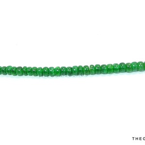 Puede incluir: Una hebra de cuentas de piedras preciosas verdes, enhebradas en un alambre de plata.