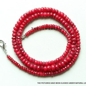 Può includere: Una collana di perle di rubino rosso con una chiusura in argento. Le perle sono sfaccettate e hanno una finitura lucida.