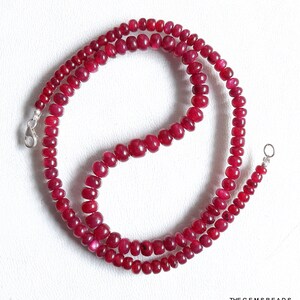 Pode incluir: Uma corda de contas de rubi vermelho escuro enfiadas em uma corrente de prata com um fecho de lagosta. O colar mede aproximadamente 45 cm de comprimento.