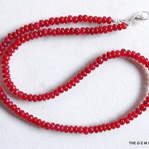 Puede incluir: Un collar de cuentas de rubí rojo en una cadena de plata. Las cuentas son redondas y de tamaño uniforme. La cadena es delicada y tiene un cierre de langosta.